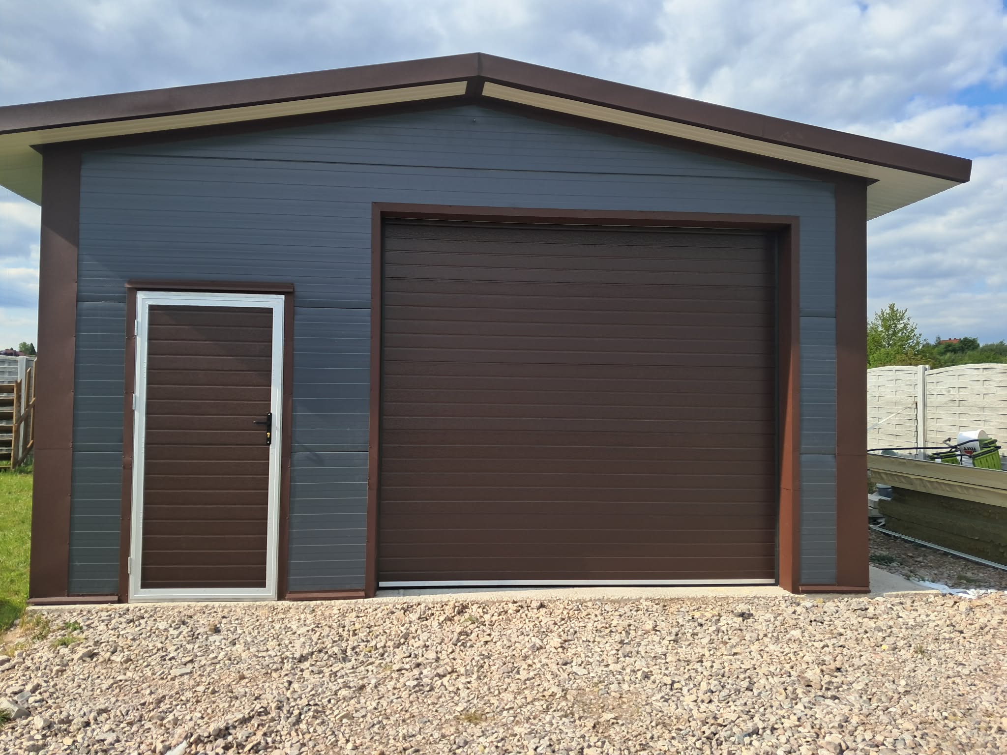 Brązowa brama segmentowa z drzwiami bocznymi