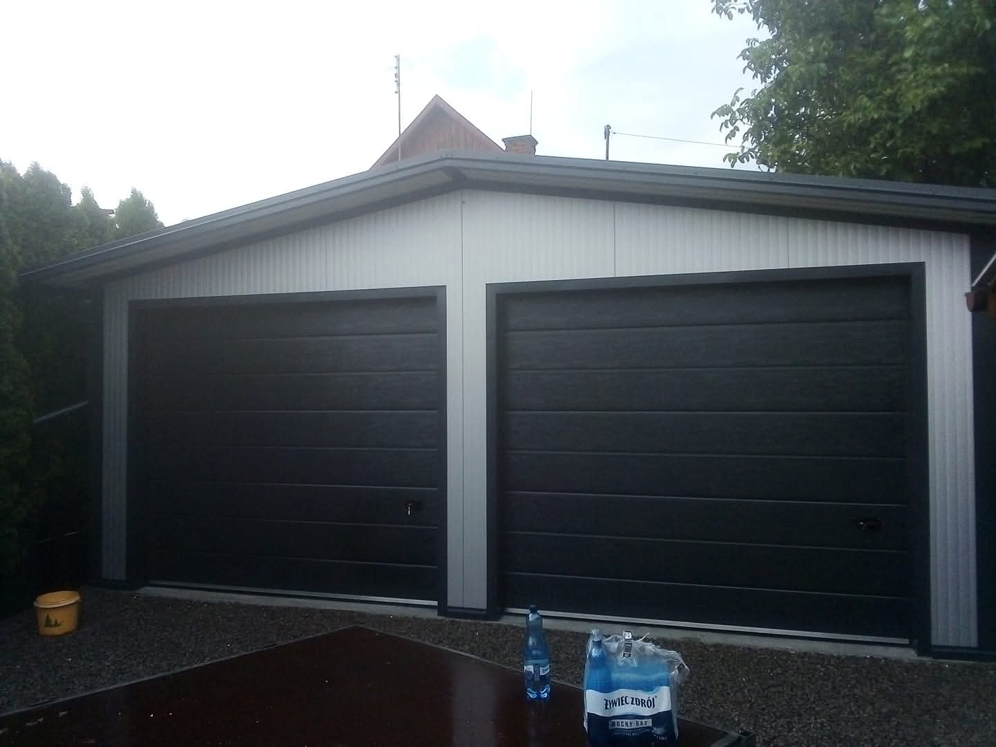 Dwie ciemne bramy segmentowe w garażu dwustanowiskowym